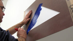 „Malen Sie mit Hilfe der Schablone ein blaues Dreieck über eine Tür. Verschenken Sie dann das Original Blatt“  - gemäß der Anleitung Blinky Palermos wird das Dreieck im Städel über einem Durchgang in den Gartenhallen angebracht.