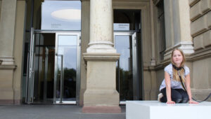 Warten vorm Museum wie ein Hund? Bereits früh am Morgen nehmen Schüler die Erwin Wurm Anweisung ernst.