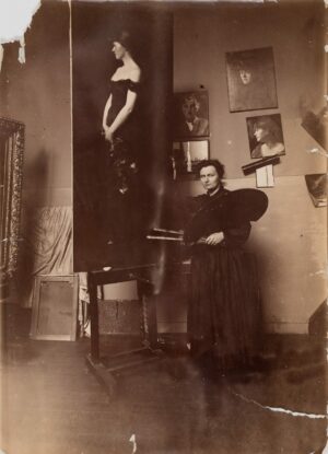 Ottilie W. Roederstein in ihrem Pariser Atelier vor ihre Gemälde Miss Mosher, 1887–1889, Fotografie, Roederstein-Jughenn-Archiv im Städel Museum, Foto: Roederstein-Jughenn-Archiv im Städel Museum, Frankfurt am Main